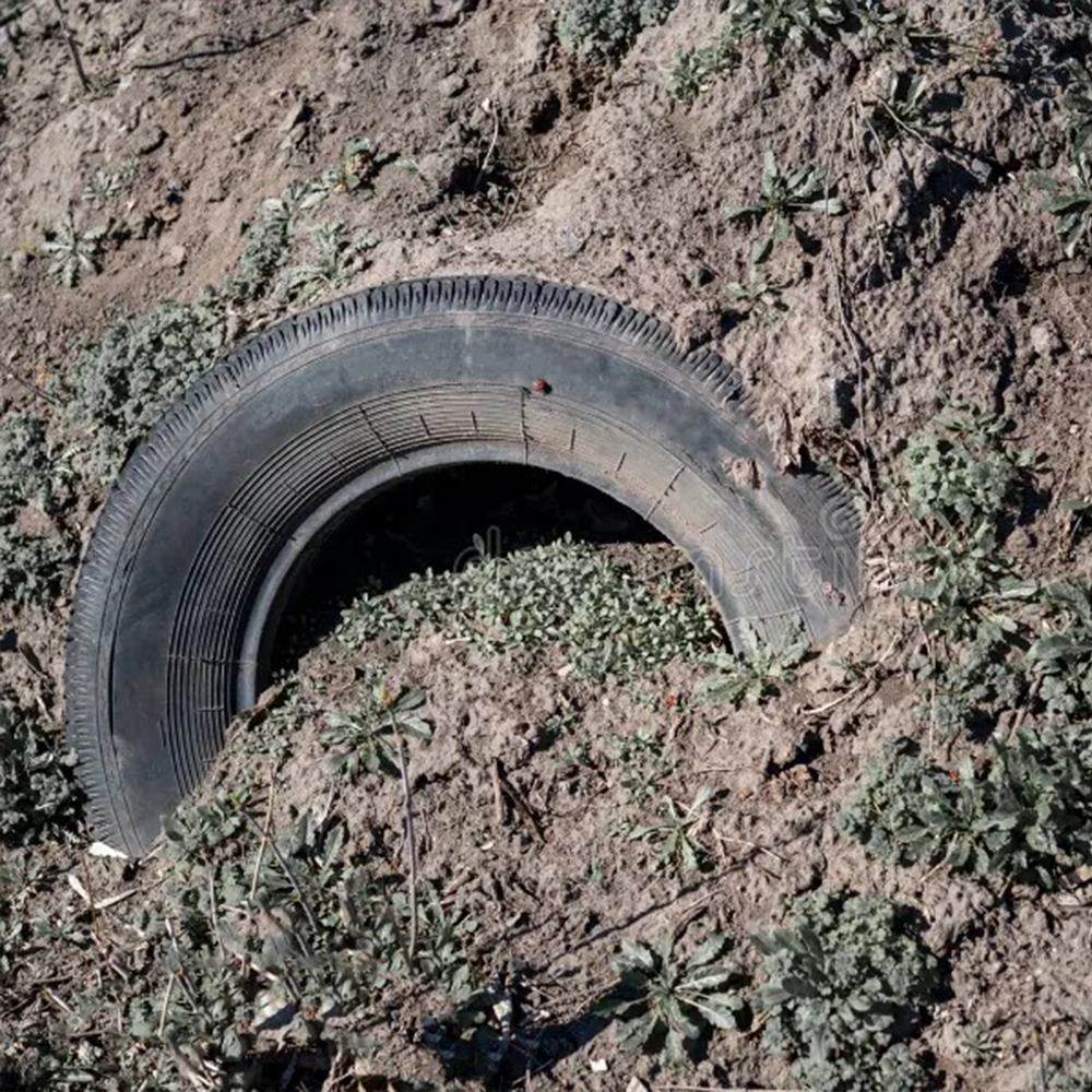 el-neumatico-esta-enterrado-en-la-basura-de-tierra-bosque-reciclaje-neumaticos-automoviles-dano